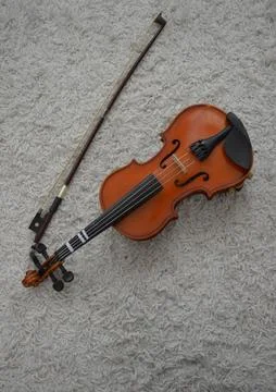 Violin bow next to it on the couch Stock Photos