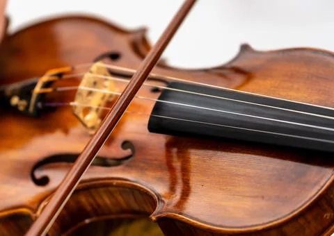 Violin bow playing strings on classical instrument Stock Photos