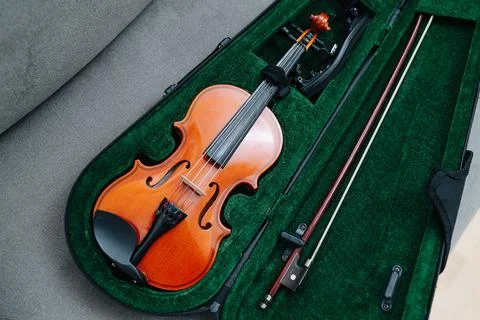Violin gently placed in a case draped in yellow cloth. High angle Stock Photos