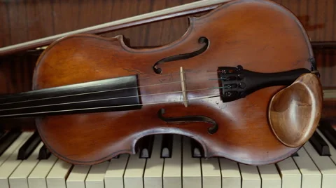 Violin lying on the piano keys. Close uo slider shot Stock Footage 65418403