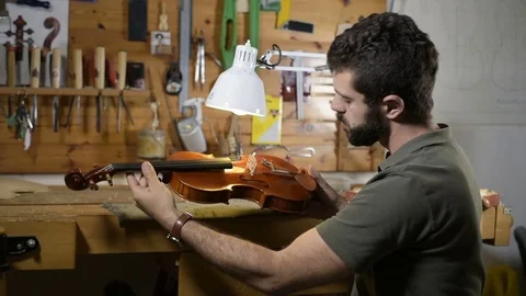 Violin maker checking finished instrument Stock Footage 75949527