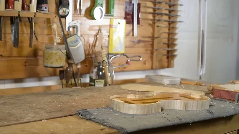 Violin maker taking musical instruments from desk Stock Footage 75950811