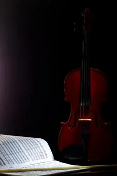 Violin with notes and bow on a black background Stock Photos