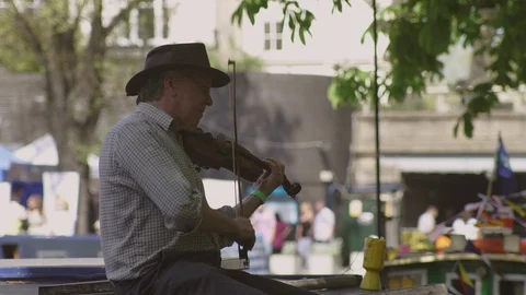 Violin player in Hat energetically playing fiddle outside on a sunny day. Stock Footage 93201304