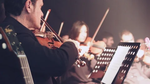 Violin player plays in string section of full Orchestra Stock Footage 86599225