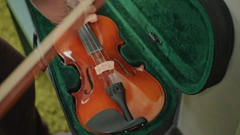 Violin setup scene. Gentle daylight accentuates varnish and rosined bow handle Stock Footage 346560405
