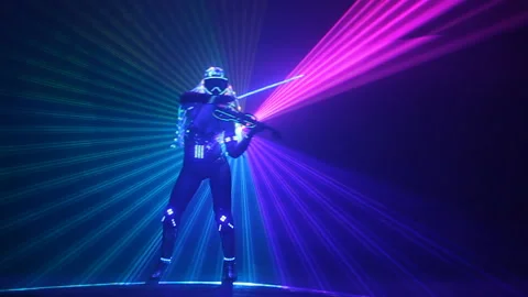 Violinist with an electronic LED violin in the rays of a laser Stock Footage 108083478