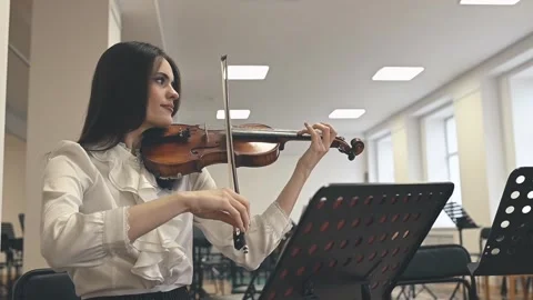 A violinist frowns after missing a note during rehearsal. The frustration is Stock Footage 305644490