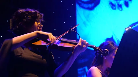 Violinist performing classical music on stage with blue lighting Video stock 301643264