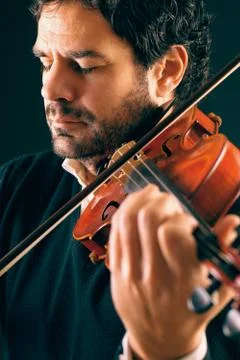 Violinist playing in black background. Stock Photos