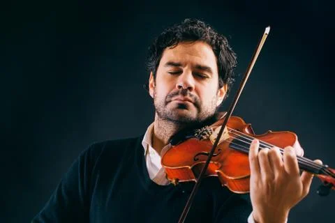 Violinist playing in black background. Stock Photos