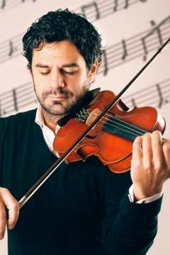 Violinist playing with a stave background Stock Photos
