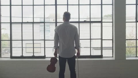 Violinist Taking a Break to Look Out the Window Video stock 208773623