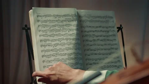 The violinist turns the notes and prepares to play the violin Stock Footage 156287962