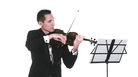 Violinist in tuxedo performs a slow composition on a classical violin. Isolated Stock Footage 134495531