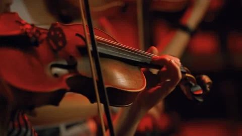 Violinists playing a fast tone ending an orchestral symphony in a concert. Video stock 285540137