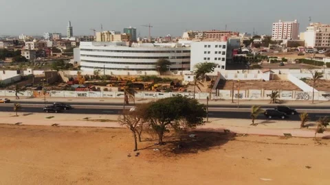 VIP Motorcade on Dakar Boulevard Seen from Beach Drone Pullback Senegal Stock Footage 338032553