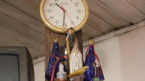 Virgin Mary by a wall clock in a kitchen Stock Footage 123481723