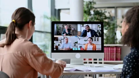 Virtual communication, video call. View over the shoulders of two women to a Stock Footage 153874646