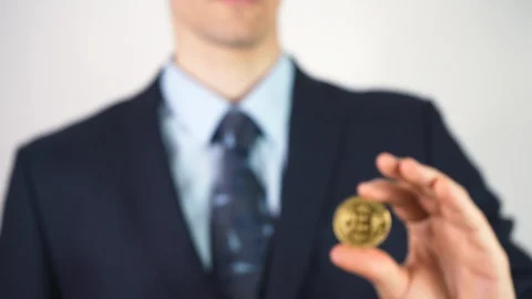 Virtual currency bitcoin concept: sharp man in a suit showing bitcoin. Crypto Stock Footage 125195366