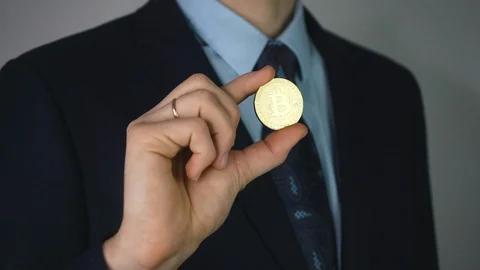 Virtual currency bitcoin concept: sharp man in a suit showing bitcoin.  Stock Footage 125251533