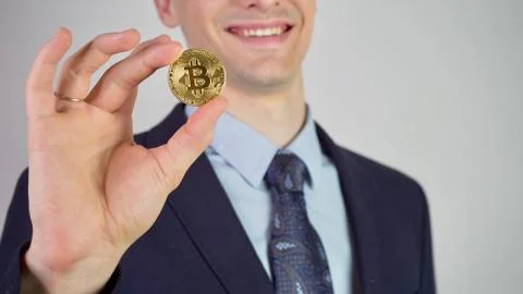 Virtual currency bitcoin concept: sharp man in a suit showing and using bitcoin. Stock Photos