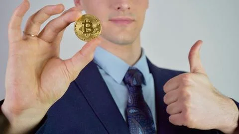 Virtual currency bitcoin concept: sharp man in a suit showing and using bitcoin. Stock Photos