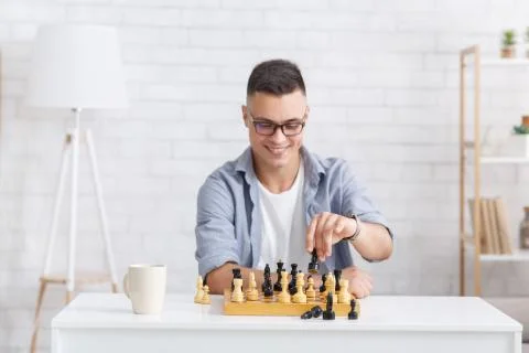 Virtual opponent in chess game. Smiling guy playing board game at online call Stock Photos