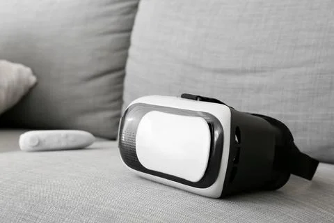 Virtual reality headset and controller on sofa, immersive gaming and digital  Stock Photos
