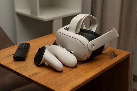 Virtual reality headset and controllers on wooden table Stock Photos