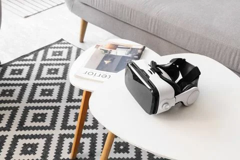 Virtual reality headset on a modern white coffee table with a magazine and ge Stock Photos