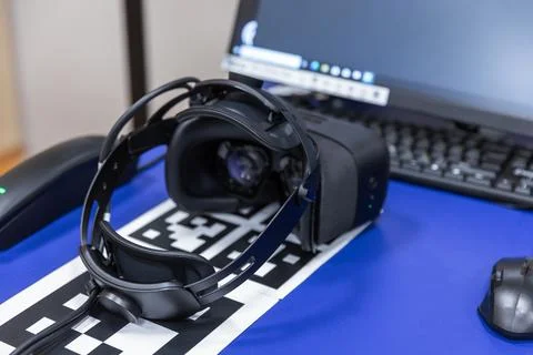 A virtual reality headset rests on an AR tracking marker Stock Photos