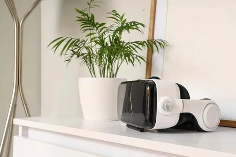 Virtual reality headset on white table with potted plant Stock Photos