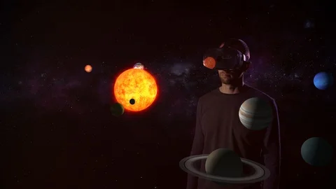 A virtual reality. A man in VR glasses looks at a model of the solar system. Stock Footage 90683852