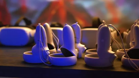 Virtual reality VR equipment on a table. VR headsets and joysticks Stock Footage 245786801