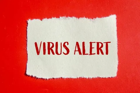 Virus alert message written on ripped torn paper piece with red background. C Stock Photos