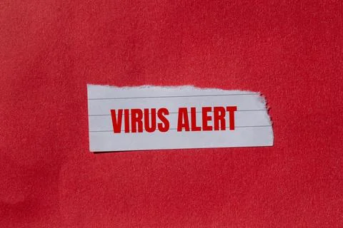 Virus alert message written on ripped torn paper piece with red background. C Stock Photos