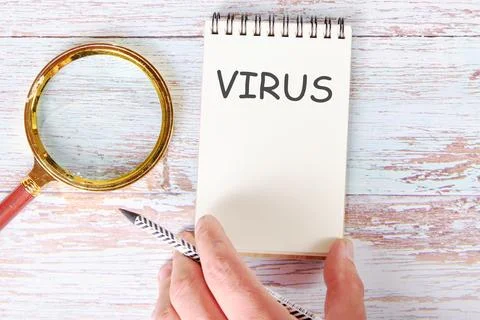 VIRUS written on a blank sheet of a notebook which is touched by a man's hand Stock Illustration