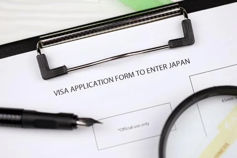 Visa application to enter Japan on A4 tablet lies on office table with pen .. Stockfoto's