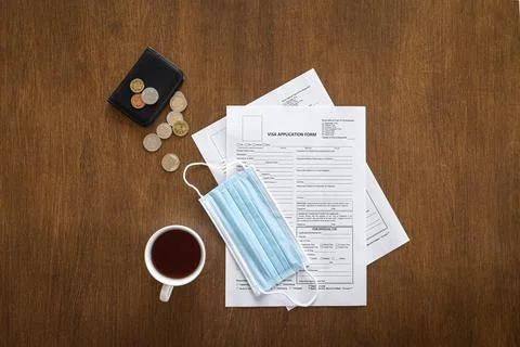 Visa application form on a wooden table, visa processing, registration, flat lay Stock Photos