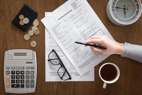 Visa application form on a wooden table, visa processing, registration, flat lay Stock Photos