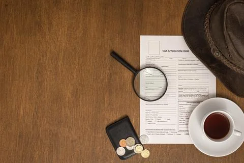 Visa application form on a wooden table, top view, flat lay, visa processing. Stock Photos