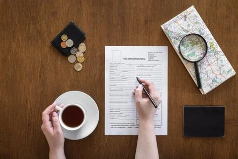 Visa application form on a wooden table, visa processing, registration, flat lay Stock Photos