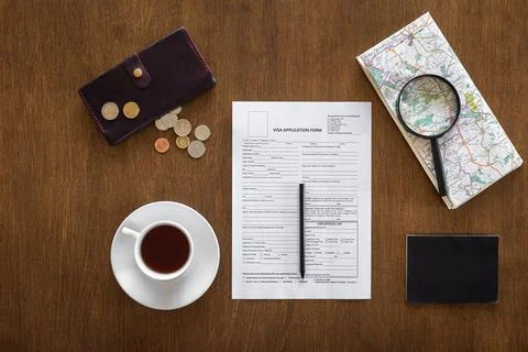 Visa application form on a wooden table, visa processing, registration, flat lay Stock Photos