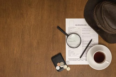 Visa application form on a wooden table, top view, flat lay, visa processing. Stock Photos