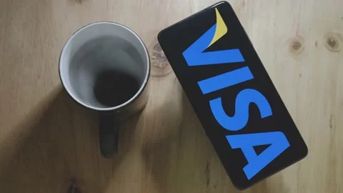 VISA logo on an Android smartphone with a hot cup of coffee Stock Footage 157275037
