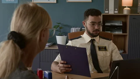 Visa Processing Officer Interviewing Blonde Senior Woman at His Workplace Stock Footage 311026826