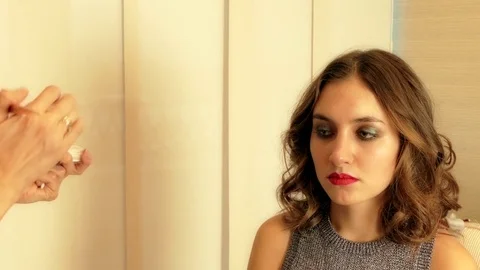 Visagiste applying make-up on brunette model's face Stock Footage 82786548