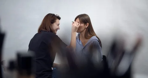 Visagiste applying makeup on models face Stock Footage 126353199
