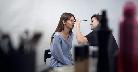 Visagiste applying makeup on models face Stock Footage 126353767